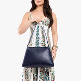 Cobalt Large | Model carrying large triangular shoulder bag with antiqued brass finished hardware