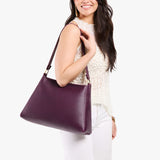 Plum Large | Model carrying large triangular shoulder bag with antiqued brass finished hardware