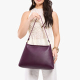 Plum Large | Model holding large triangular shoulder bag with antiqued brass finished hardware
