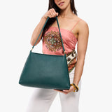 Sea Glass Large | Model holding large triangular shoulder bag with antiqued brass finished hardware