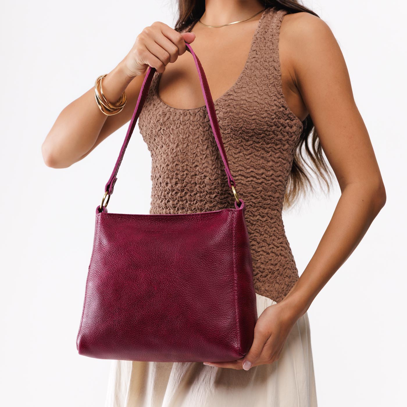 Orchid*Classic | Model carrying leather triangular shoulder bag with zipper top closure and wide shoulder strap