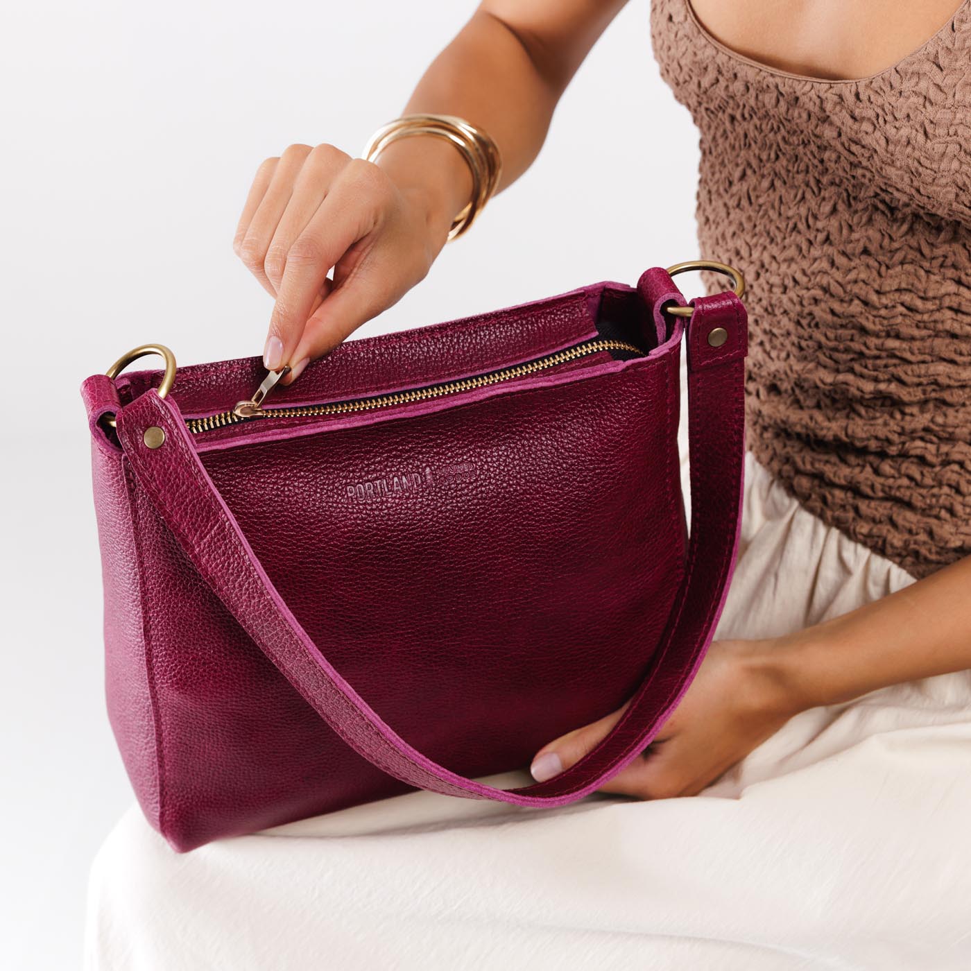 Orchid*Classic | Model holding triangular shoulder bag with antiqued brass finished hardware