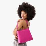 Royalty Small | Model holding a triangular shoulder bag with antiqued brass finished 