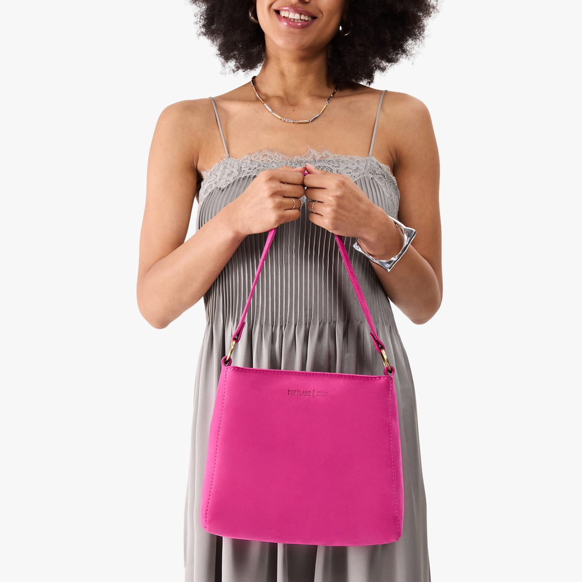 Royalty*Small | Model holding a triangular shoulder bag with antiqued brass finished 
