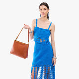 Sienna Classic | Model holding triangular shoulder bag with antiqued brass finished hardware