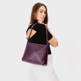 Plum Classic | Model carrying triangular shoulder bag with antiqued brass finished hardware