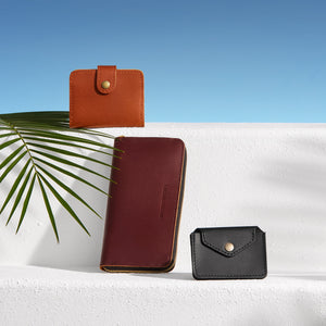 Three leather wallets in different colors on a white surface with a blue gradient background.