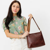 Cognac Classic | Model holding triangular shoulder bag with antiqued brass finished hardware