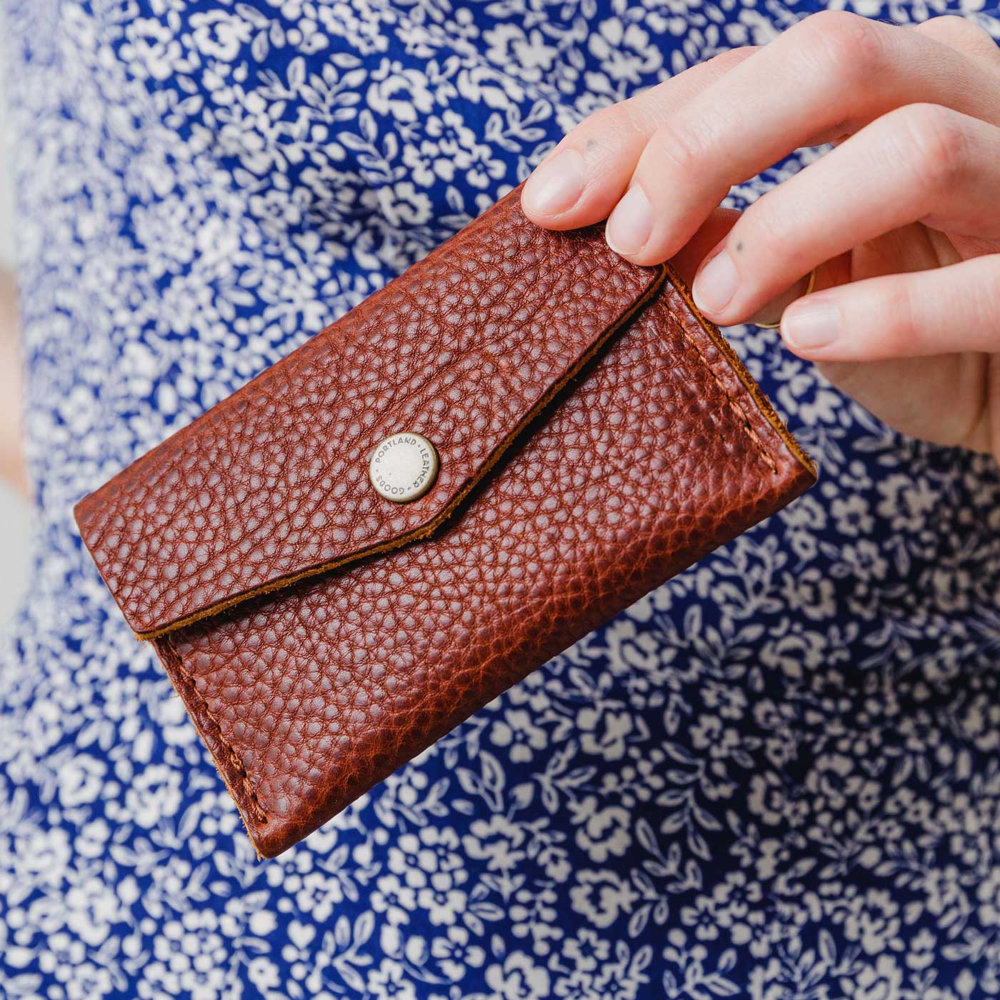 Nutmeg | Model holding small leather envelope wallet with snap closure